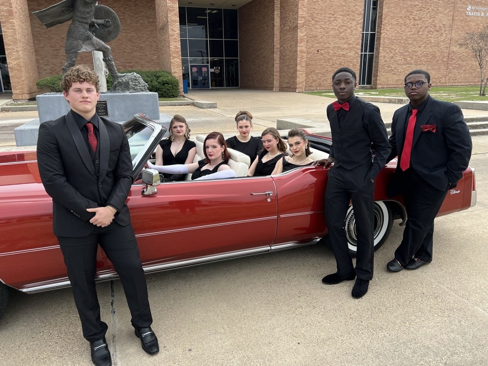 Members of Vocal Legacy posing by a classic car in a promo for their performances