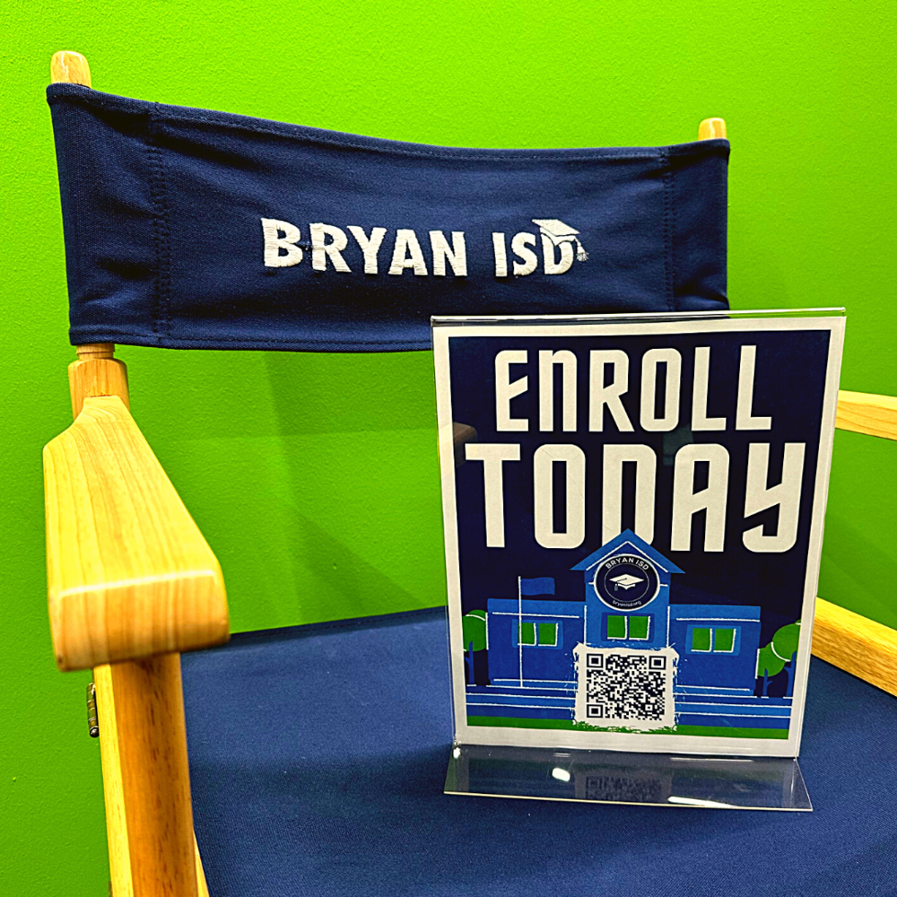 An "Enroll Today" flyer sitting on a Bryan ISD directors chair against a green background
