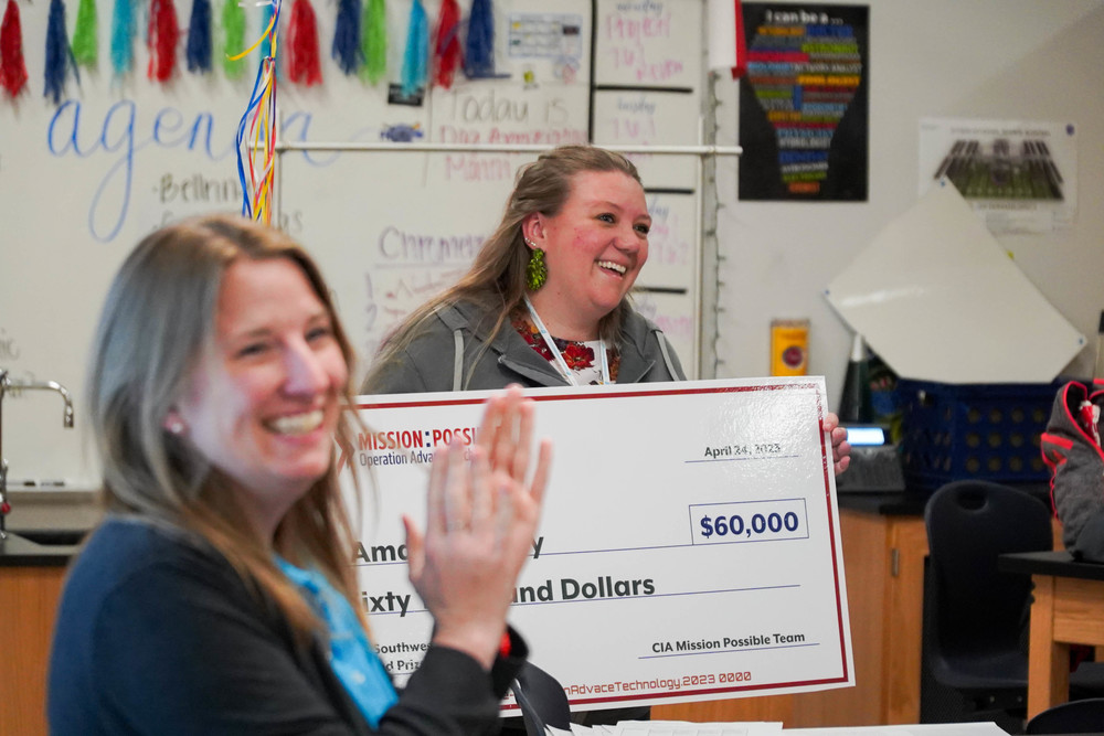 Amanda Petty smiles as she receives her $60,000 grant with ORISE associate manager Jennifer Tyrell clapping in the foreground