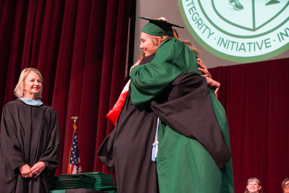 Rachel and Allison Layton hug as Allison receives her high school diploma