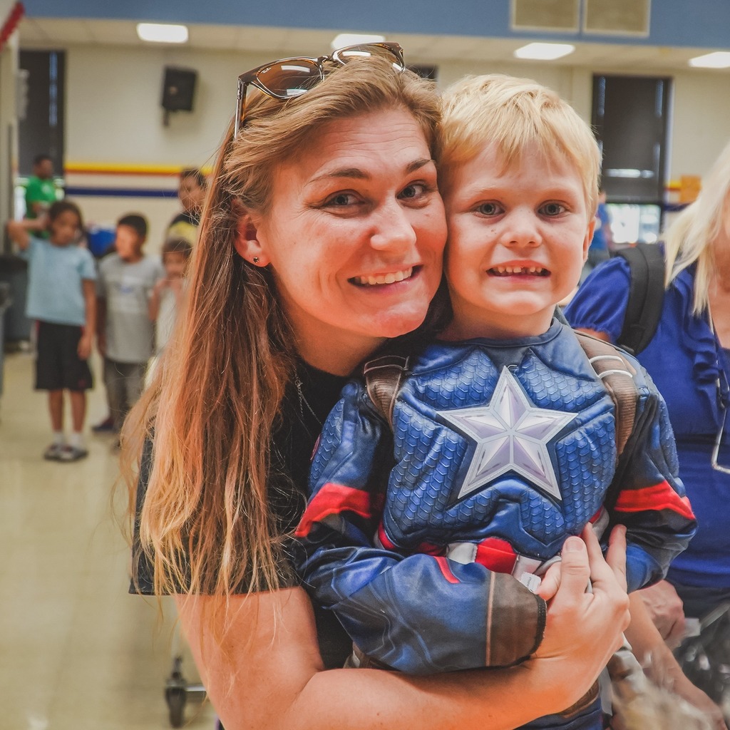 Mom smiling with boy in Captain America outfit
