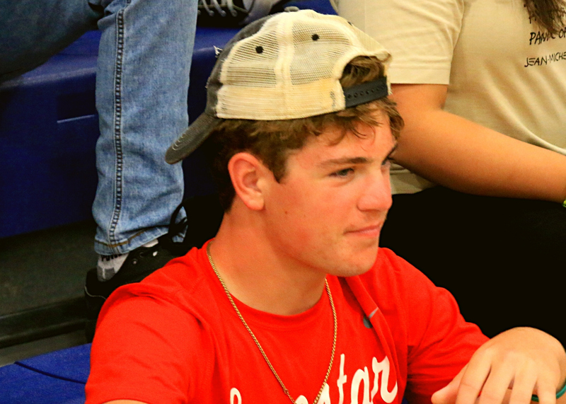 student wearing red shirt and backwards baseball cap